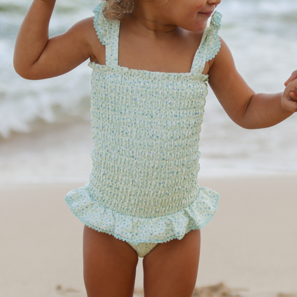 little baby wearing minnow smocked one piece on beach