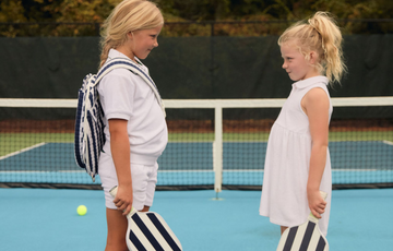 two girls wearing minnow terry clothing on tennis court