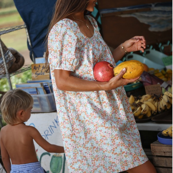 women wearing minnow hawaiian floral cover-up at fruit stand